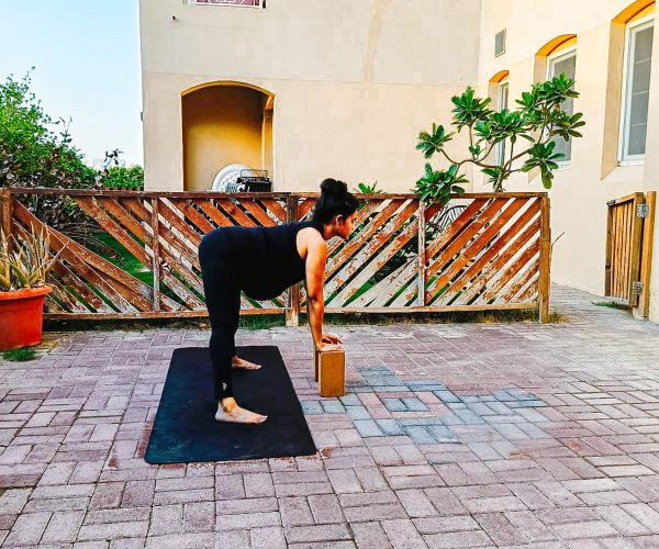 Wide Stance Forward Bend During Pregnancy Image of a Pregnant lady practicing Wide Stance Forward Bend Pose.